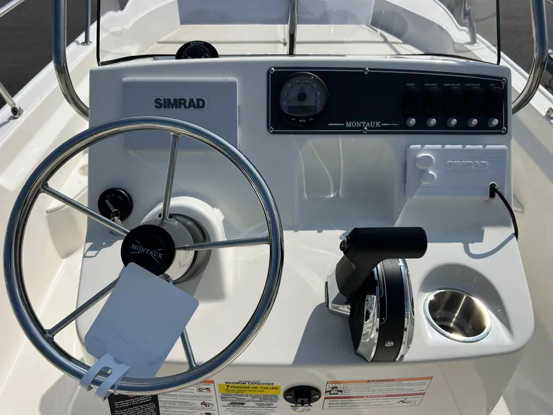 Slide: The Image of 2025 Boston Whaler 170 Montauk boat console with steering wheel and controls. - 10