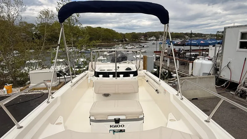 Slide: The Image of 2025 Boston Whaler 170 Montauk boat docked, featuring spacious deck and canopy. - 2