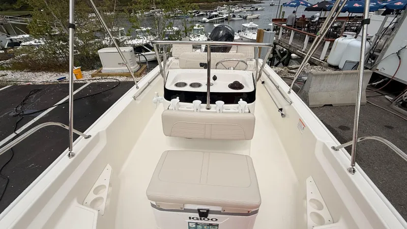 Slide: The Image of 2025 Boston Whaler 170 Montauk boat interior with seating and console, docked at marina. - 3