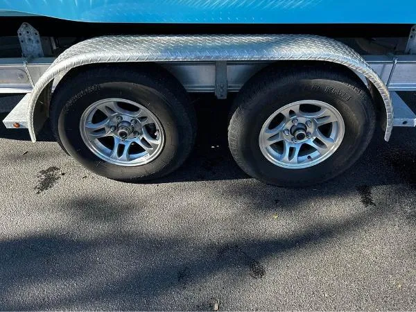 Slide: The Image of Trailer wheels of 2024 NauticStar 231 Hybrid boat on pavement. - 10