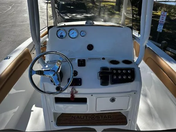 Slide: The Image of 2024 NauticStar 231 Hybrid boat dashboard with steering wheel and gauges. - 12