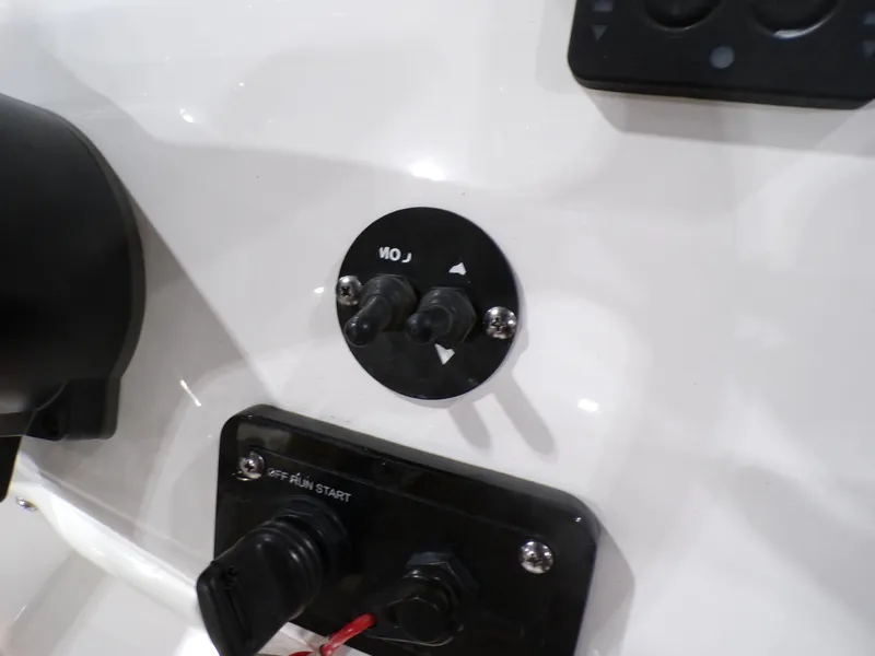 Slide: The Image of Control panel of 2024 NauticStar 231 Hybrid boat, featuring switches and ignition. - 16