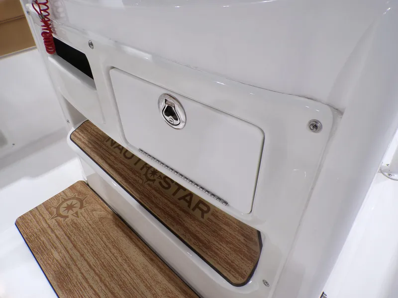 Slide: The Image of 2024 NauticStar 231 Hybrid boat interior with wood accents and storage compartment. - 19