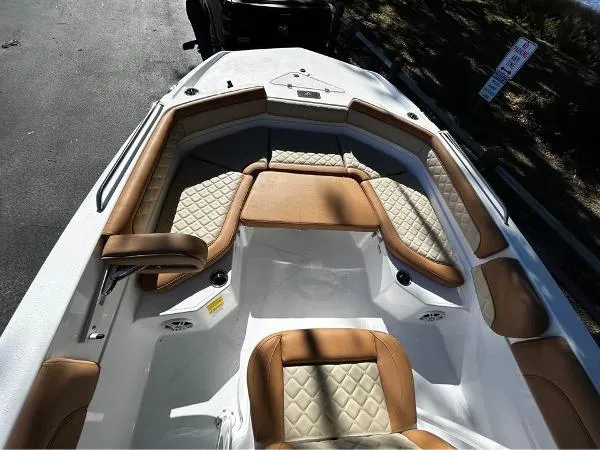 Slide: The Image of 2024 NauticStar 231 Hybrid boat interior with tan and white cushioned seating. - 21