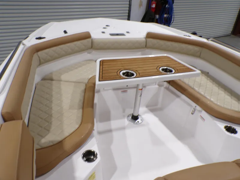 Slide: The Image of 2024 NauticStar 231 Hybrid boat interior with cushioned seating and wooden table. - 23