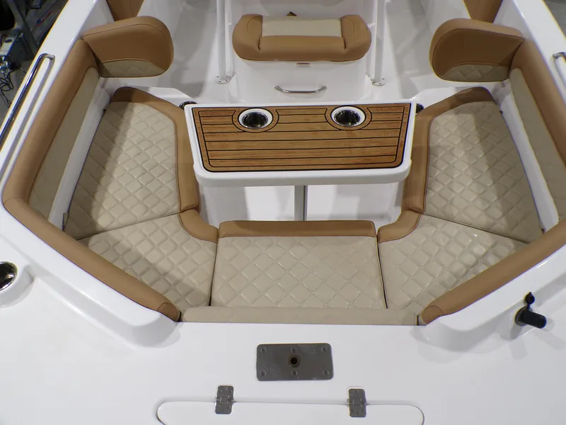 Slide: The Image of 2024 NauticStar 231 Hybrid boat interior with cushioned seating and wooden table. - 25