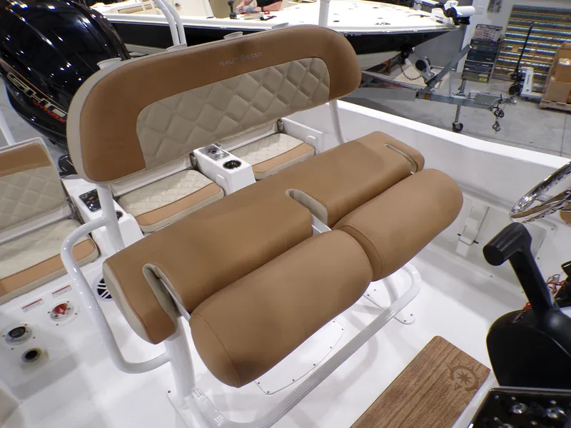 Slide: The Image of 2024 NauticStar 231 Hybrid boat interior with tan cushioned seating and white accents. - 32