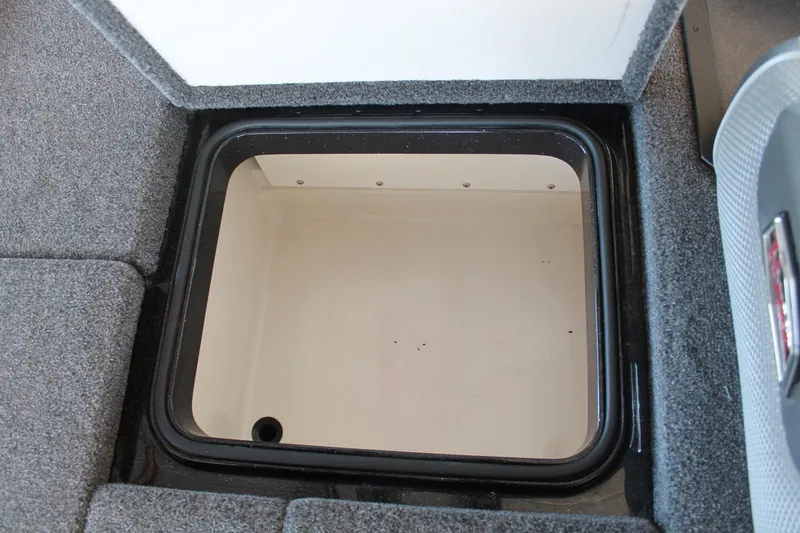 Slide: The Image of 2020 Ranger Z185 boat storage compartment with gray carpeted interior. - 31
