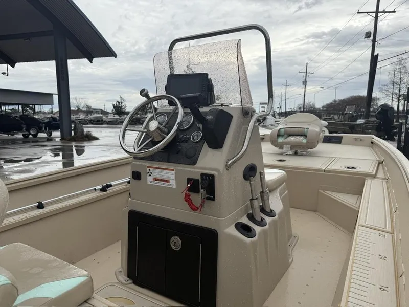 Slide: The Image of 2021 G3 17 BAY boat interior with steering console and seating, parked outdoors. - 9