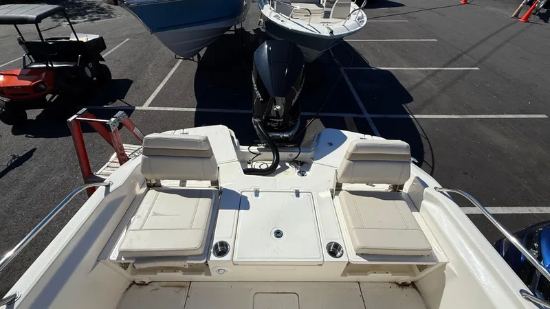 Slide: The Image of 2025 Boston Whaler 250 Dauntless boat interior with seating and motor, parked in a lot. - 6