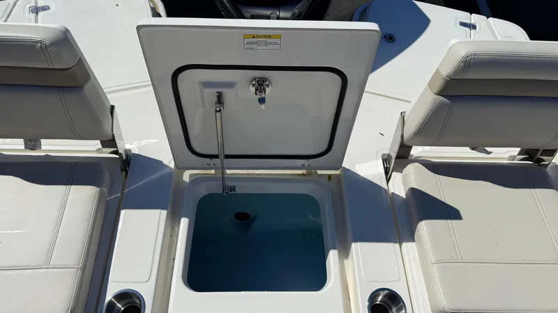 Slide: The Image of 2025 Boston Whaler 250 Dauntless boat with open storage compartment and seating area. - 7