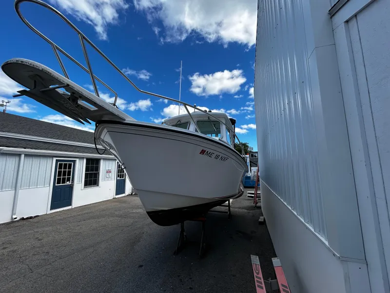 Slide: The Image of 2014 Steiger Craft 21 DV MIAMI boat on trailer, parked beside a building under a blue sky. - 10