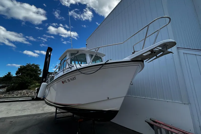 Slide: The Image of 2014 Steiger Craft 21 DV MIAMI boat docked near a building under a blue sky. - 6