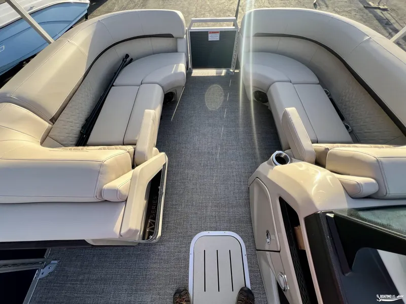 Slide: The Image of Interior view of 2025 Bennington M22 pontoon boat with beige seating and carpeted floor. - 3