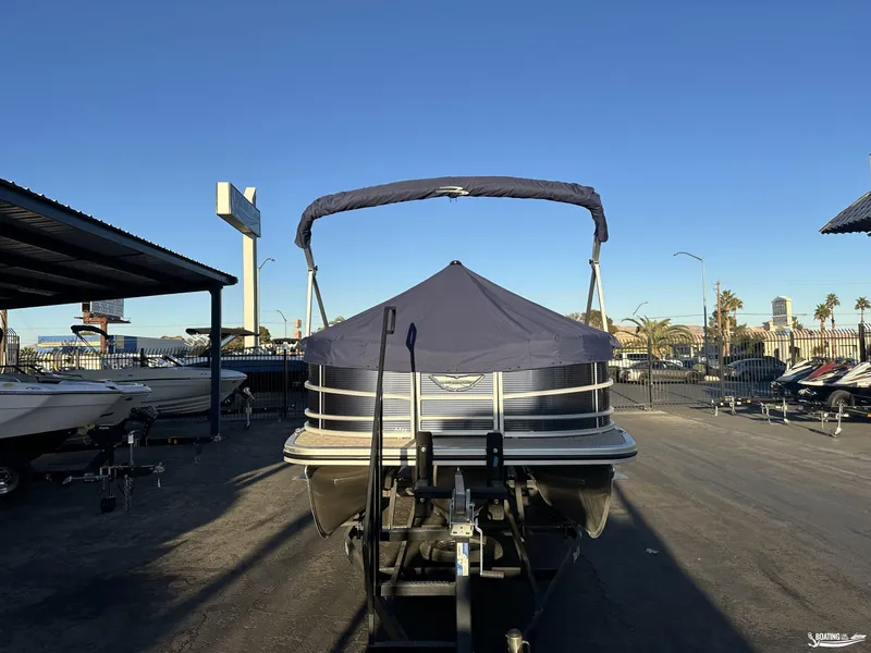 Slide: The Image of 2025 Bennington M22 pontoon boat on trailer, covered and parked outdoors. - 5
