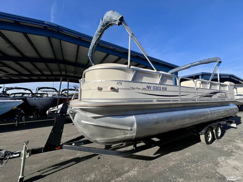 Slide: The Image of 2005 Sun Tracker PARTY BARGE 25 pontoon boat on trailer under a metal canopy. - 2