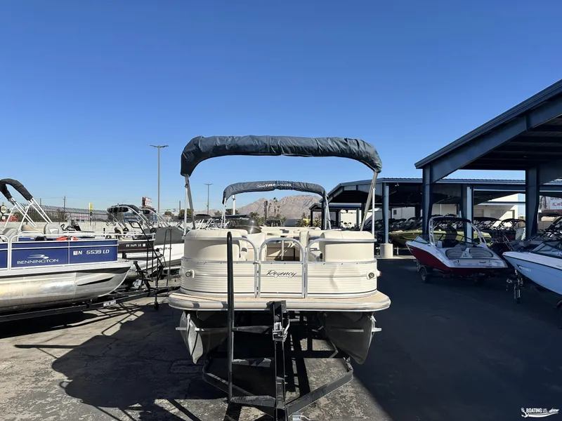 Slide: The Image of 2005 Sun Tracker PARTY BARGE 25 pontoon boat in a marina under clear blue sky. - 3