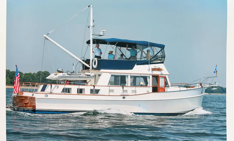 Slide: The Image of 1999 Grand Banks Classic yacht cruising on open water with passengers on deck. - 0