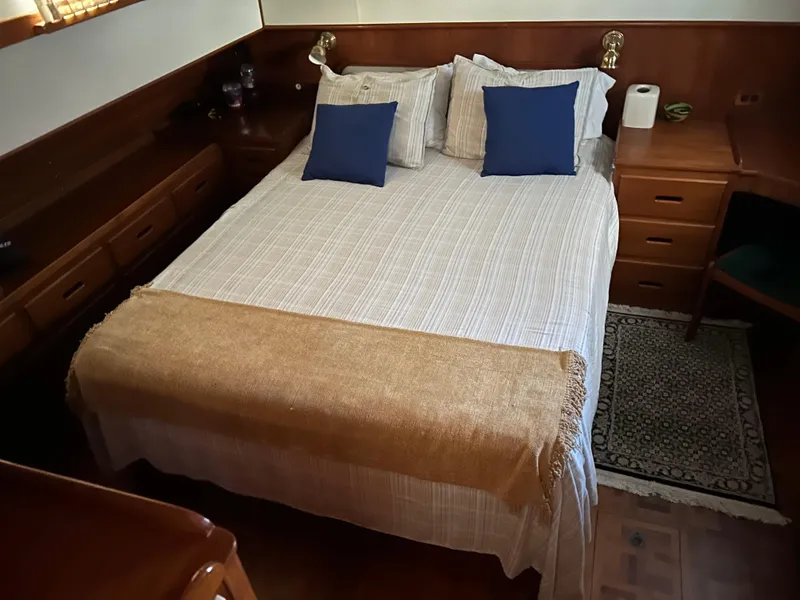 Slide: The Image of Cozy bedroom interior on 1999 Grand Banks Classic yacht with elegant bedding and wooden furnishings. - 11