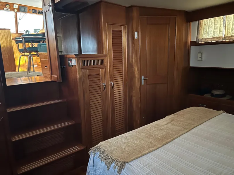 Slide: The Image of Interior of 1999 Grand Banks Classic yacht with wooden cabinetry and cozy bedroom. - 12