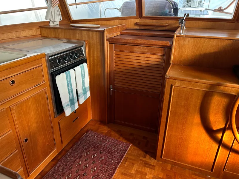 Slide: The Image of 1999 Grand Banks Classic yacht interior with wooden cabinetry and kitchen area. - 18