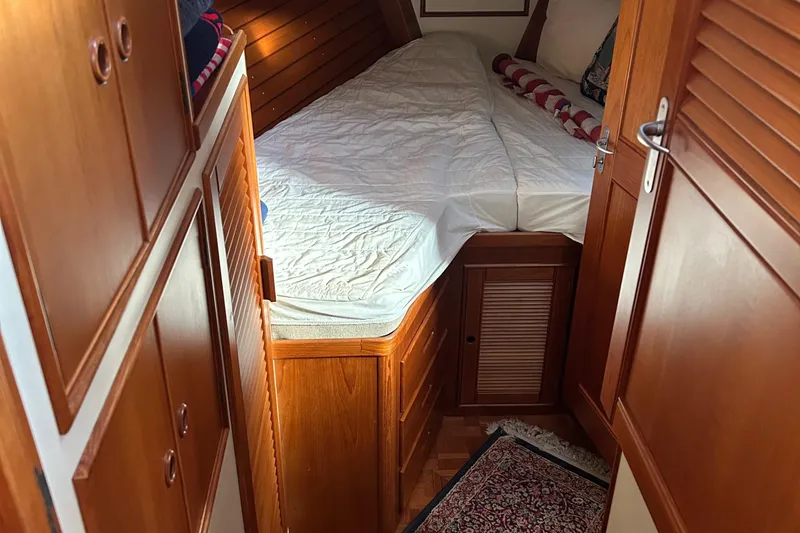 Slide: The Image of 1999 Grand Banks Classic cabin interior with wooden finish and cozy bed. - 19