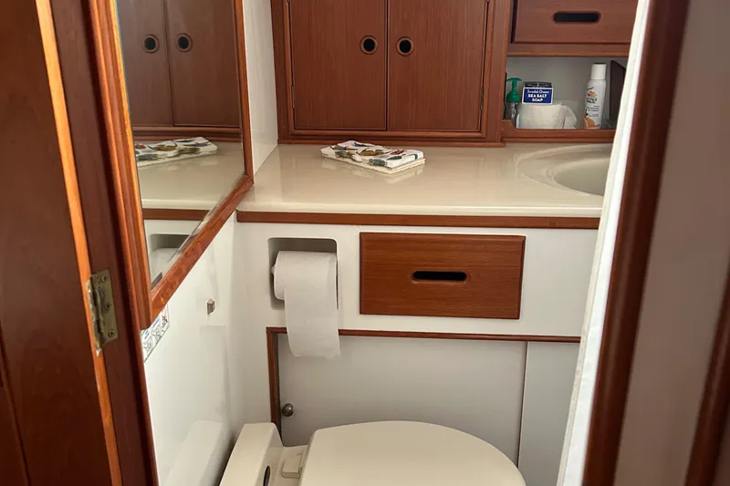 Slide: The Image of Bathroom interior of 1999 Grand Banks Classic yacht, featuring wooden cabinetry and a compact design. - 20