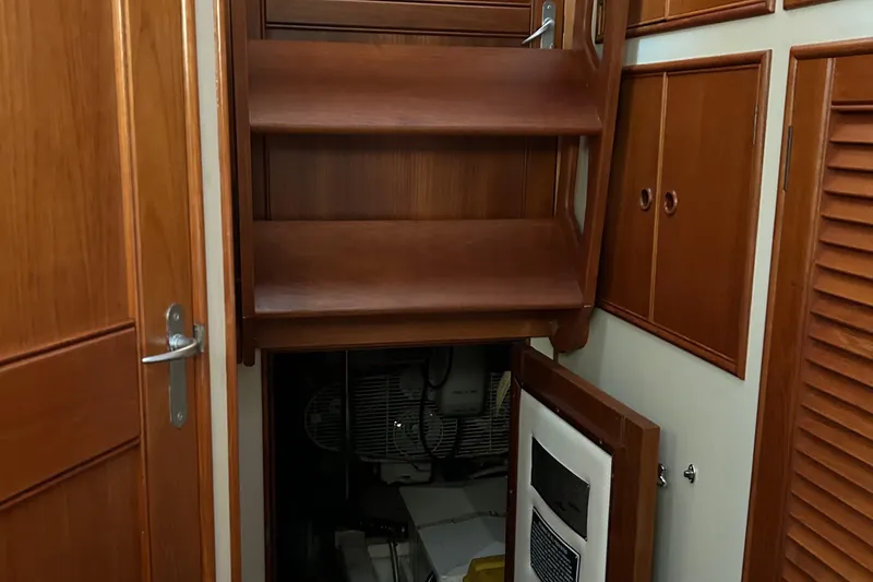 Slide: The Image of 1999 Grand Banks Classic interior with wooden cabinetry and access panel. - 23