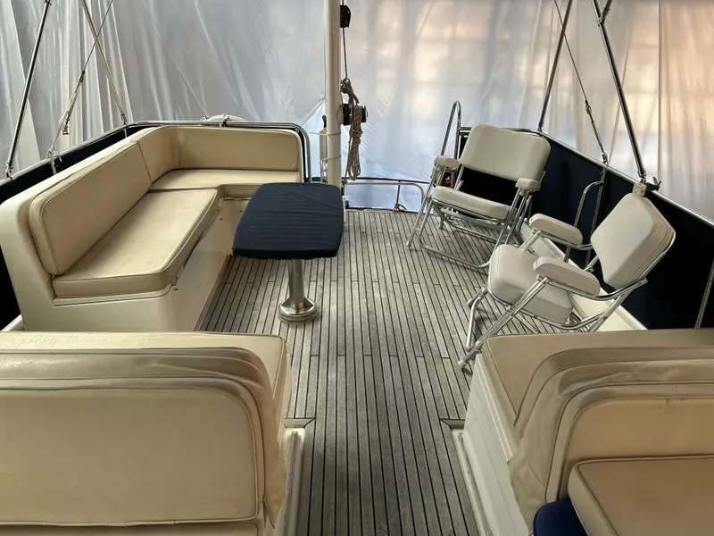 Slide: The Image of 1999 Grand Banks Classic yacht interior with cushioned seating and wooden deck. - 25