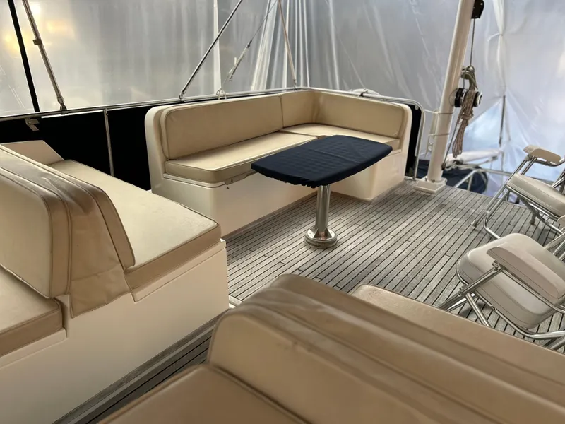 Slide: The Image of 1999 Grand Banks Classic yacht interior with beige seating and wooden deck. - 26