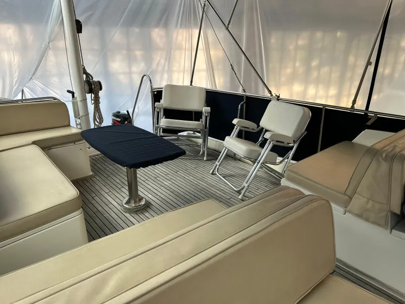 Slide: The Image of Spacious seating area on a 1999 Grand Banks Classic yacht with beige cushions and a small table. - 27
