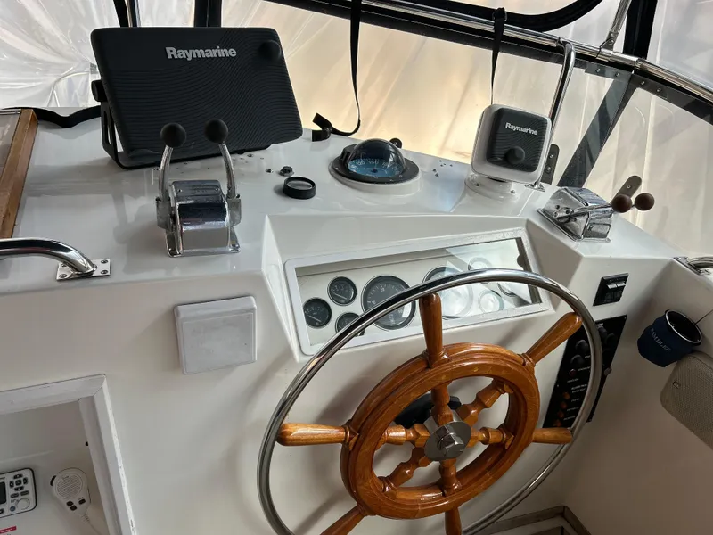 Slide: The Image of 1999 Grand Banks Classic helm with wooden wheel and Raymarine navigation equipment. - 28