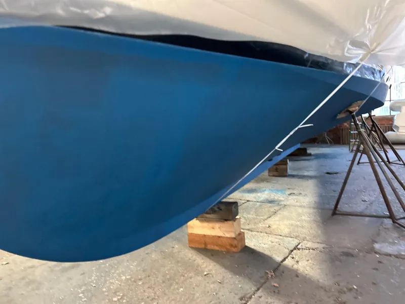 Slide: The Image of 1999 Grand Banks Classic boat hull in dry dock, featuring a fresh blue paint job. - 41