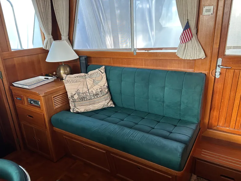 Slide: The Image of Interior of 1999 Grand Banks Classic yacht with green cushioned seating and nautical decor. - 5