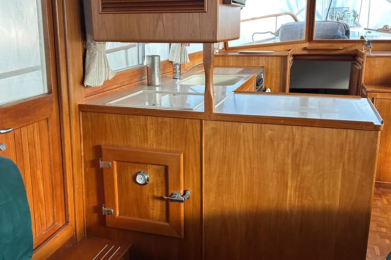 Slide: The Image of Interior of 1999 Grand Banks Classic yacht with wooden cabinetry and compact kitchen area. - 6