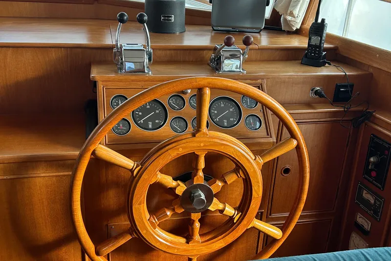 Slide: The Image of 1999 Grand Banks Classic helm with wooden wheel and control panel. - 9
