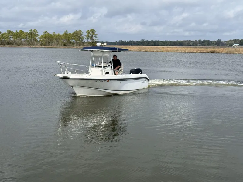 Slide: The Image of 1999 Boston Whaler 23 Outrage boat cruising on a calm lake. - 1