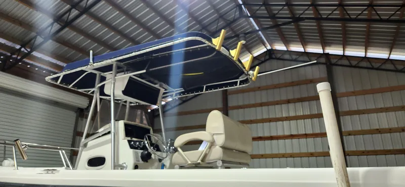 Slide: The Image of 1999 Boston Whaler 23 Outrage boat with canopy in a storage facility. - 13