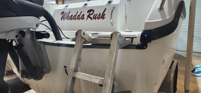 Slide: The Image of 1999 Boston Whaler 23 Outrage boat with "Whadda Rush" name and ladder. - 17