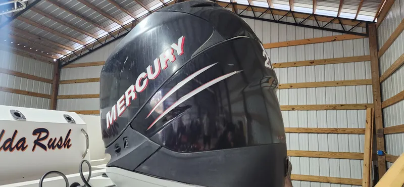 Slide: The Image of 1999 Boston Whaler 23 Outrage with Mercury engine in a storage facility. - 18