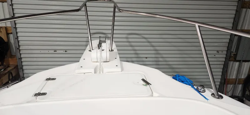 Slide: The Image of 1999 Boston Whaler 23 Outrage boat bow with stainless steel railings and blue rope. - 20