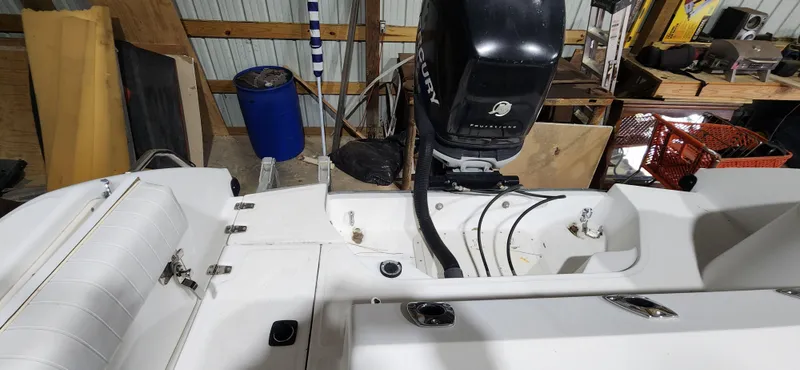 Slide: The Image of 1999 Boston Whaler 23 Outrage boat interior with Mercury engine in a storage area. - 23