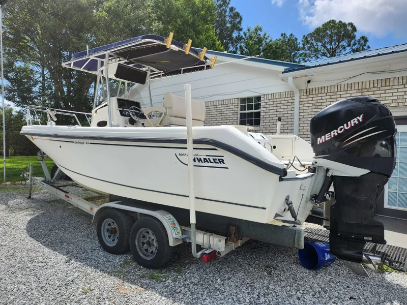 Slide: The Image of 1999 Boston Whaler 23 Outrage boat on trailer with Mercury outboard motor. - 25