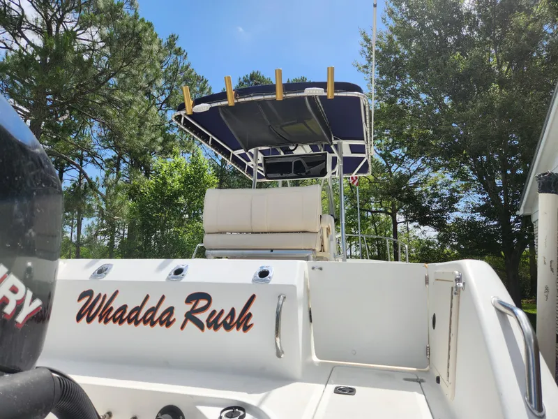 Slide: The Image of 1999 Boston Whaler 23 Outrage boat with "Whadda Rush" text, trees in background. - 26