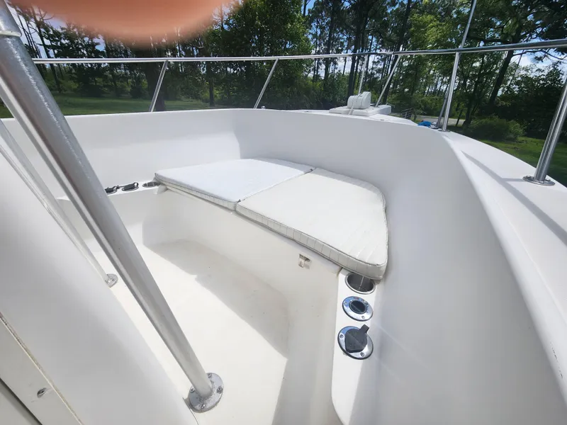 Slide: The Image of 1999 Boston Whaler 23 Outrage boat interior with cushioned seating and stainless steel railings. - 27