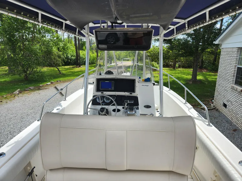 Slide: The Image of 1999 Boston Whaler 23 Outrage boat interior with console and seating, parked outdoors. - 28