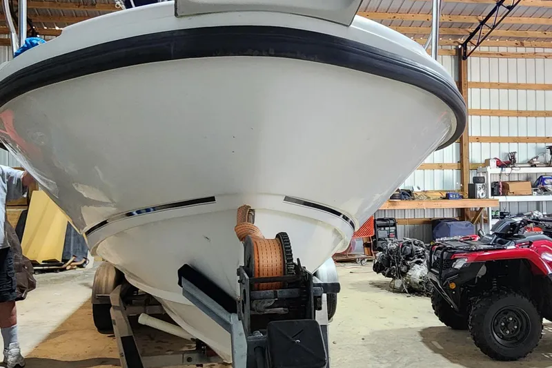 Slide: The Image of 1999 Boston Whaler 23 Outrage boat in a garage with ATV nearby. - 6