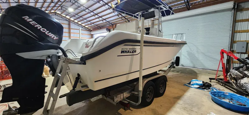 Slide: The Image of 1999 Boston Whaler 23 Outrage boat on trailer in a storage facility. - 7
