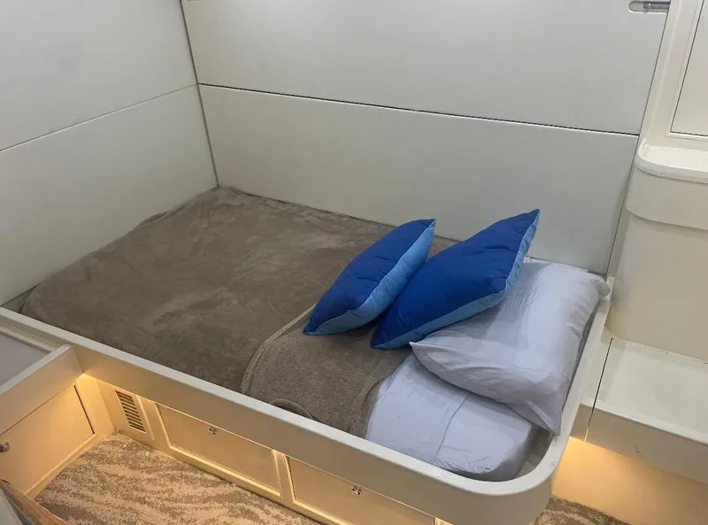 Slide: The Image of Cozy cabin bed with blue pillows in 1990 Striker Sportfish boat interior. - 13