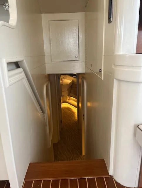 Slide: The Image of Interior hallway of a 1990 Striker Sportfish boat, featuring wooden steps and white walls. - 15